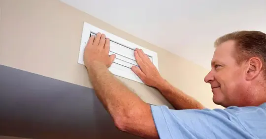 Man with Both Hands on Closed Air Vent to Reduce Air Circulation Register